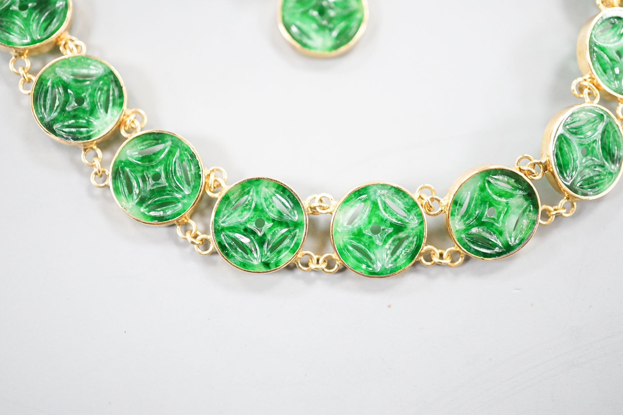 A Chinese 850 yellow metal and jade disc bracelet, 15cm and a matching small pendant, gross 9.7 grams.